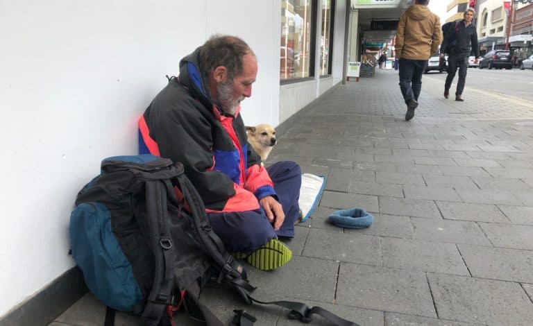Homeless Man Sitting on the street with his dog